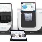 Two modern, white Essilor ES 800 and ES 800M Lens Edging Systems with integrated digital displays, accompanied by a tablet showing user interface options.